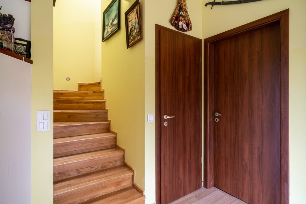 Budakeszi családi ház belső tere természetes fa burkolatokkal, lépcsővel, fa beltéri ajtókkal.
